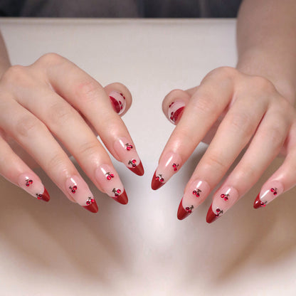 Kunstvolle Stiletto-Nägel mit Kirschmotiven und Glitzerakzenten Brehn