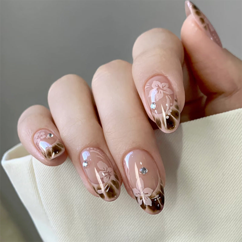 Elegante Künstliche Nagelkunst mit floralem Design und Glitzerakzenten Brehn