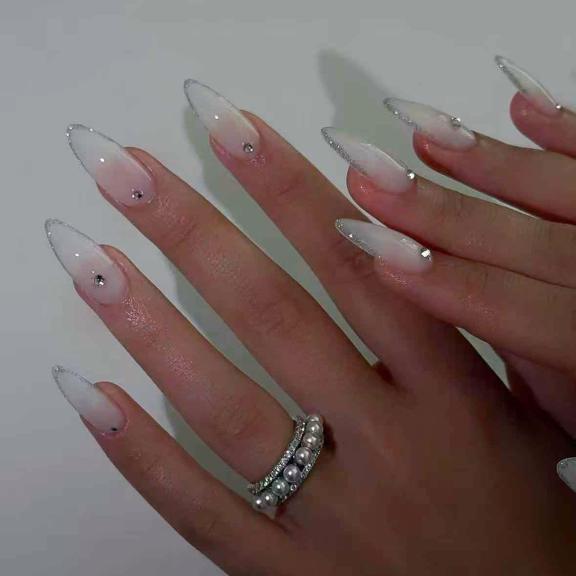 Kunstnagelset mit eleganten Spitzen und funkelnden Akzenten Brehn