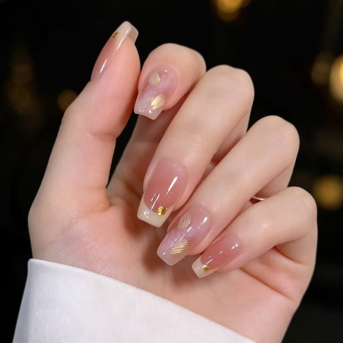 Elegante französische Nagelverlängerungen mit goldenen Akzenten