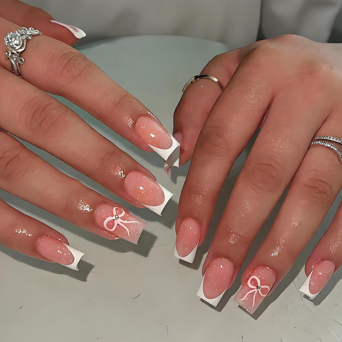 Kunstnagelset mit eleganten Spitzen und zarten Schleifenmotiven Brehn
