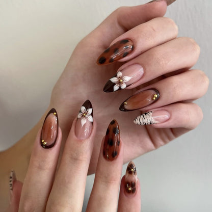 Kunstvolle Stiletto-Nägel mit eleganten Blumenmotiven und Glitzerakzenten Brehn