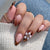 Kunstnagelset mit detailliertem Ombre-Design und kreativen Blütenakzenten Brehn