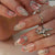 Dekoratives Press-On Nagelkunst-Set mit floralen und schimmernden Akzenten Brehn