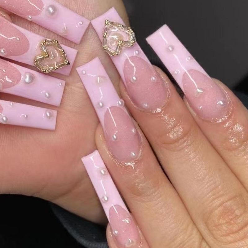 Kunstvolle Nagelkunst mit Herz- und Perlenakzenten Brehn