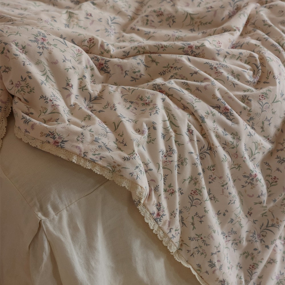 Gesteppte Wohndecke aus Baumwoll‑Mischgewebe mit zartem Blumenmuster und Spitzenkante