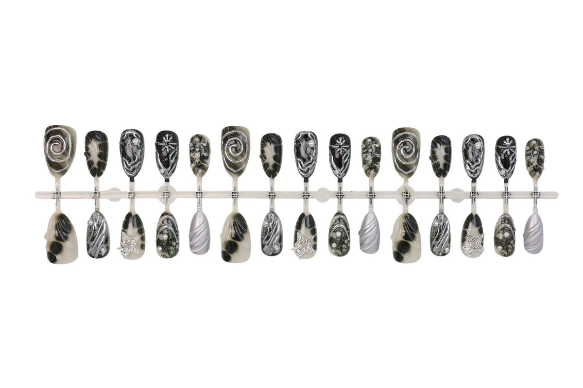 Kunstnagelset mit künstlerischen Mustern und Glitzerakzenten Brehn