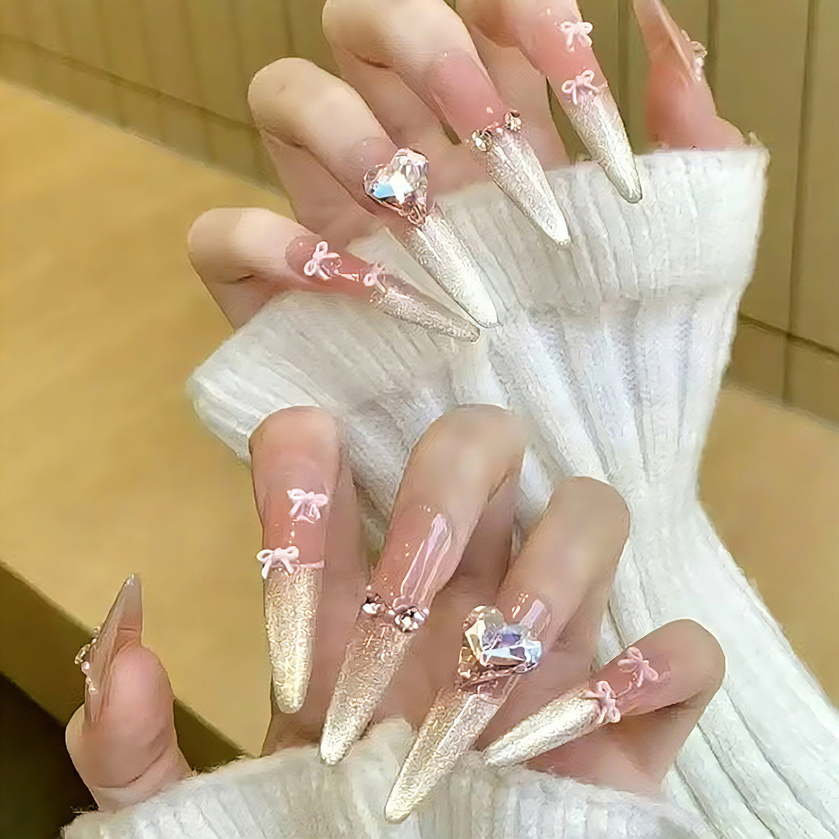Kunstnagelset mit funkelnden Spitzen und zarten Schleifenverzierungen Brehn