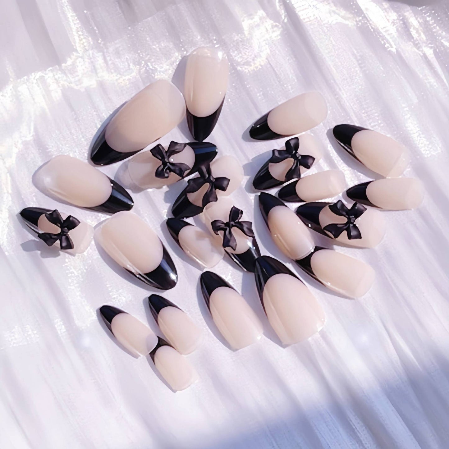 Künstlerisches Stiletto Press-On Nageldesign mit Schleifenakzenten Brehn
