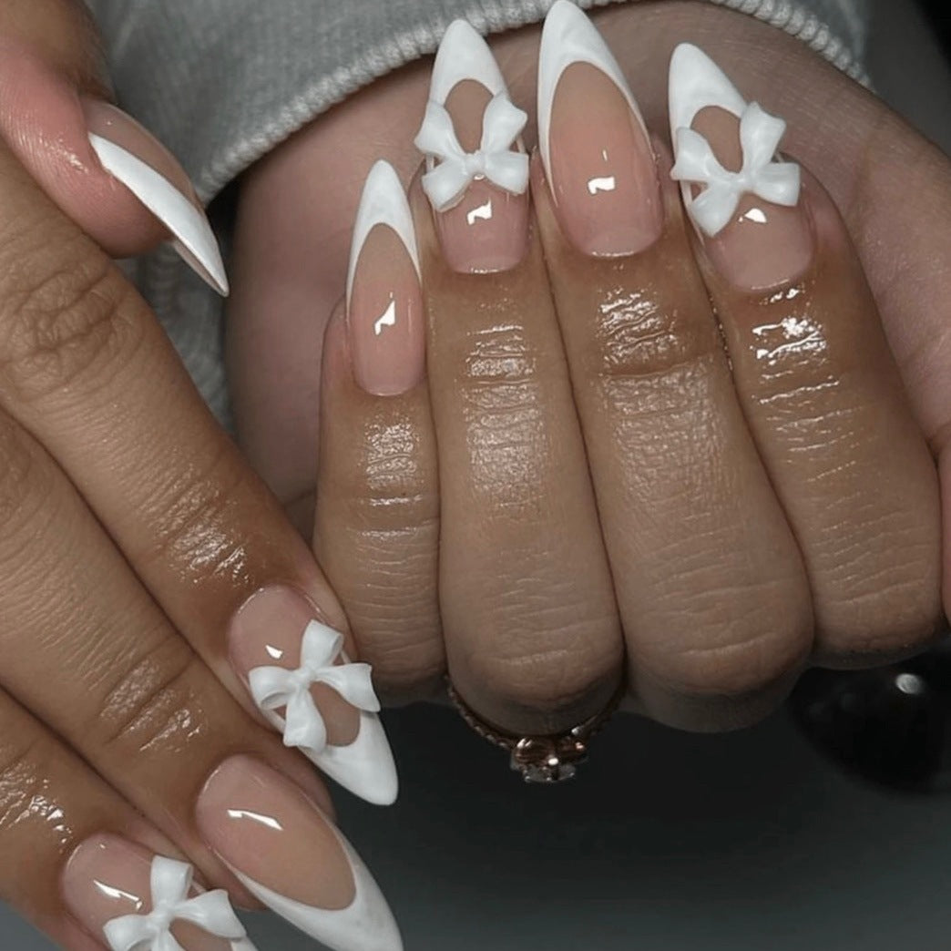 Kunstnagelset mit eleganten Spitzen und zarten Schleifenverzierungen Brehn