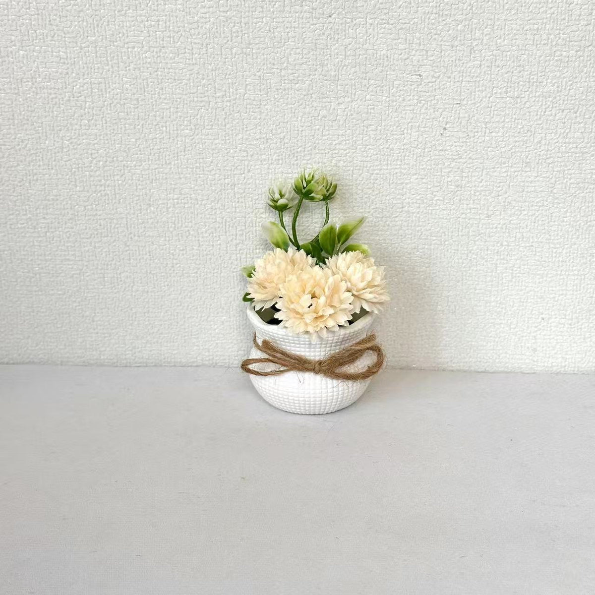Dekorative Mini-Blumenarrangement im Topf