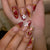 Kunstnagelset mit floralen und glamourösen Goldverzierungen Brehn