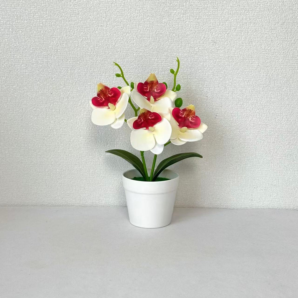 Elegante dekorative Orchideen-Blumenarrangement für die Wohnungseinrichtung