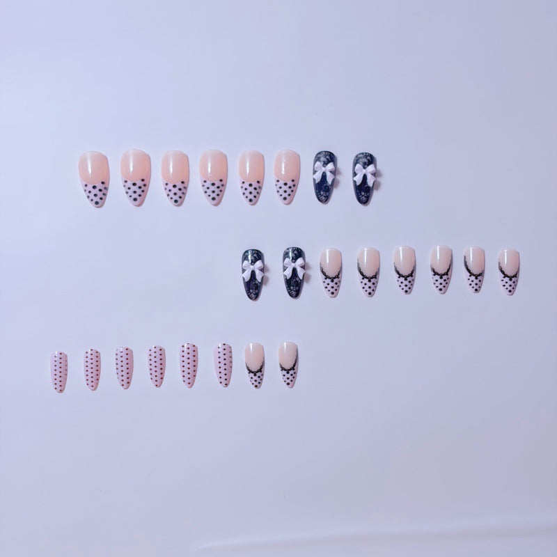 Elegante Kunstnägel mit Spitzendesign und Schleifenakzenten Brehn