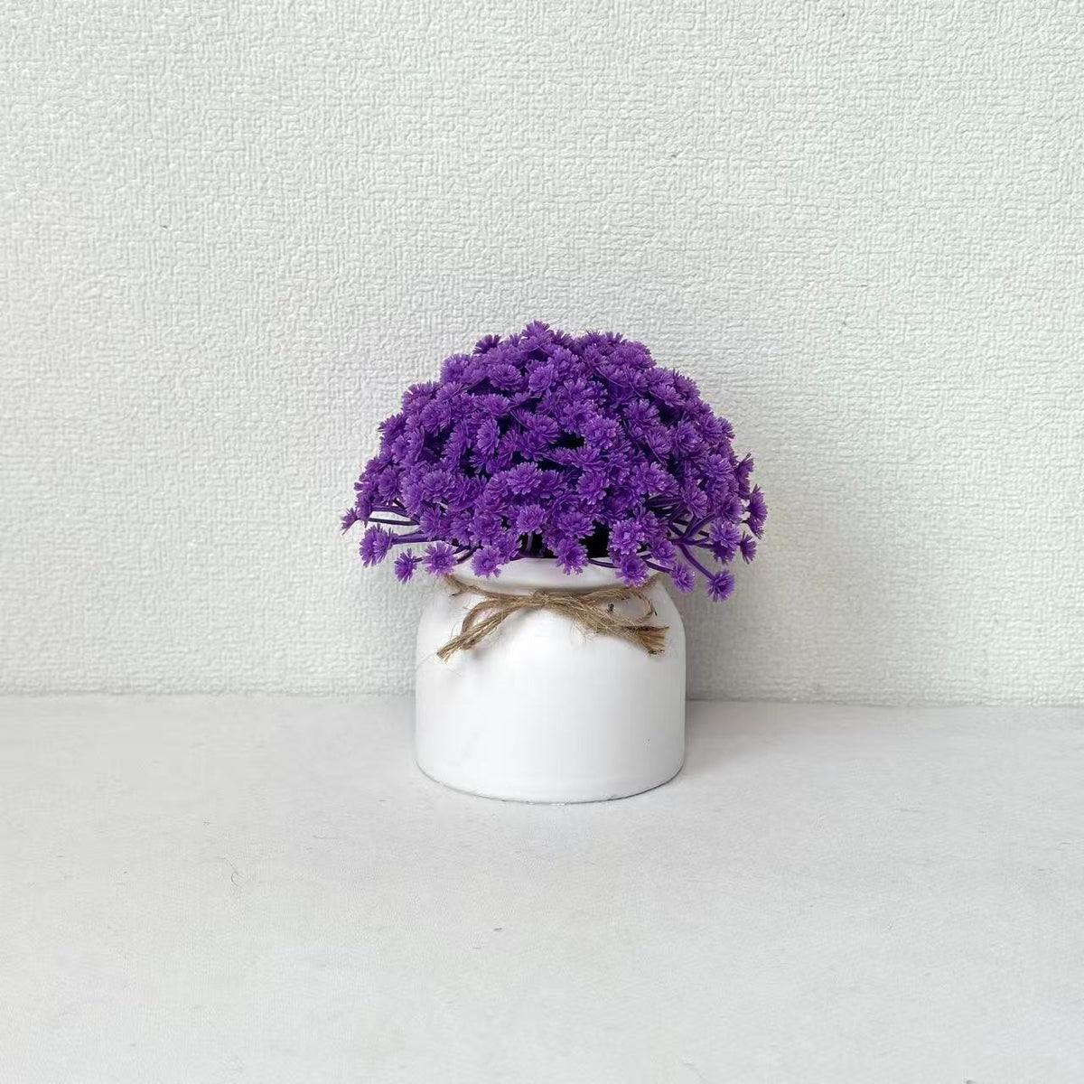 Lebensechte Lila Blumenarrangement