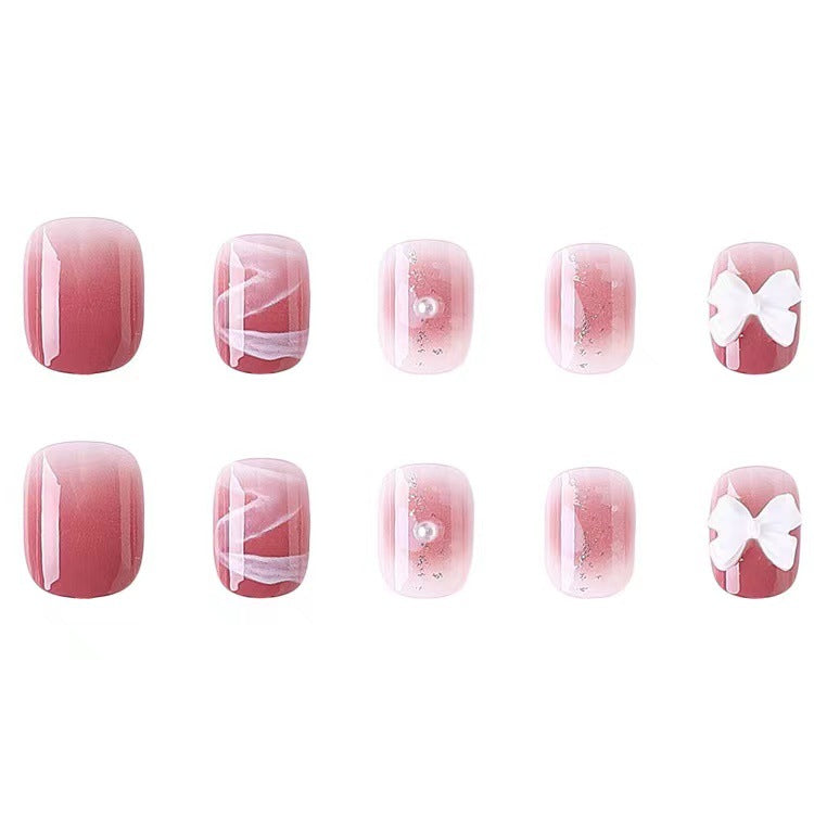 Glamouröse Nagelkunst mit Perlen- und Schleifenakzenten Brehn
