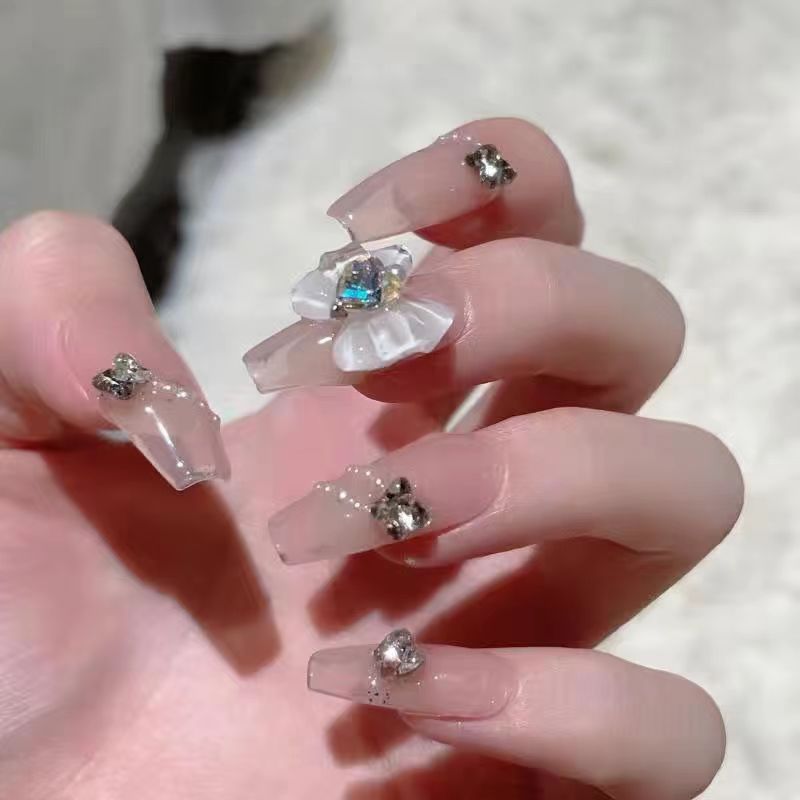 Kunstvolle Nagelkunst mit Glitzer- und Blumenapplikationen Brehn
