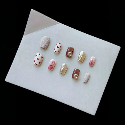 Künstlerisches Press-On-Nagelset mit Herz- und Glitzerelementen