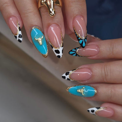 Künstlerische Stiletto-Nagelverlängerungen mit Kuhmotiv und goldenen Akzenten Brehn