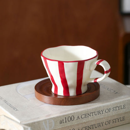 Skulpturale Keramik-Kaffeetasse mit geschwungenem Rand und markantem Streifendekor