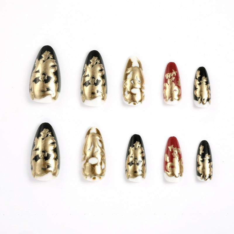 Elegante Kunstnägel mit Gold- und Schwarzmuster Brehn