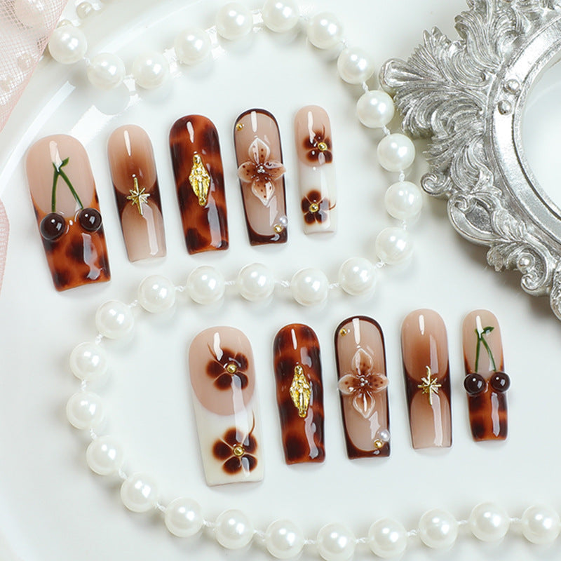 Elegantes Nagelkunstset mit floralen und goldenen Akzenten Brehn