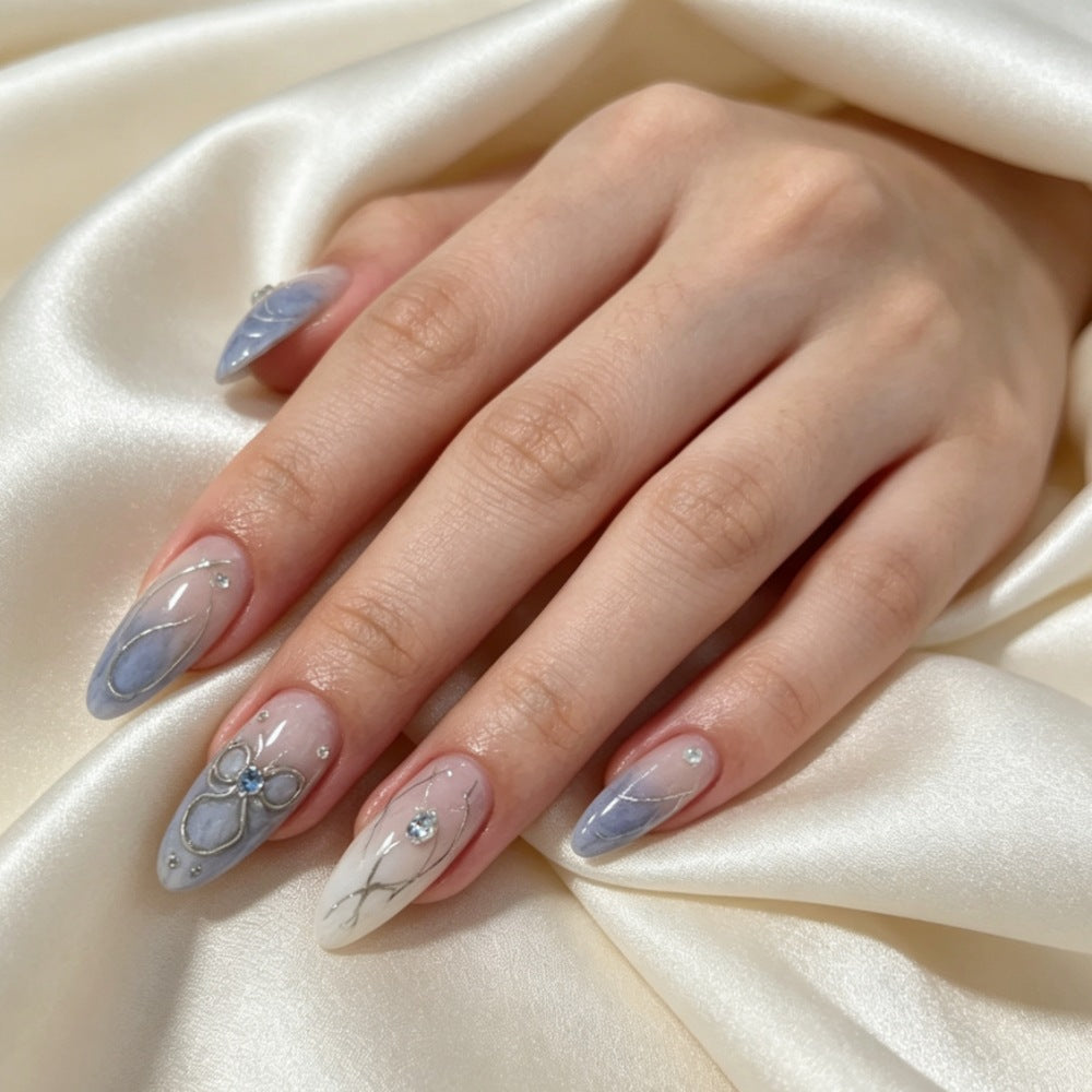 Künstlerisches Press-On-Nageldesign mit floralen und Schmuckakzenten Brehn