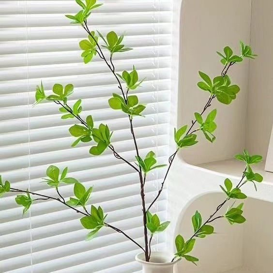 Elegante Glasvase mit lebensechter Grünpflanzenanordnung