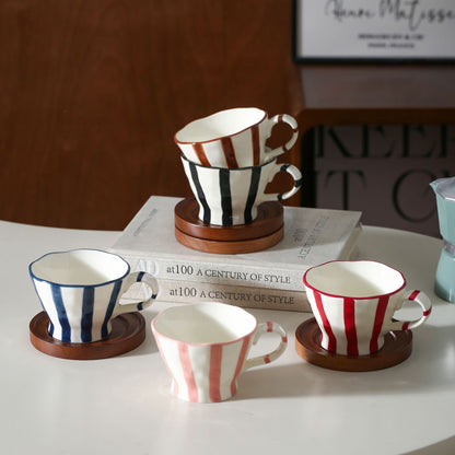 Skulpturale Keramik-Kaffeetasse mit geschwungenem Rand und markantem Streifendekor