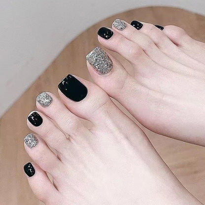 Kunstvolle Fußnagelkunst mit Glitzer- und Schwarzdesign Brehn