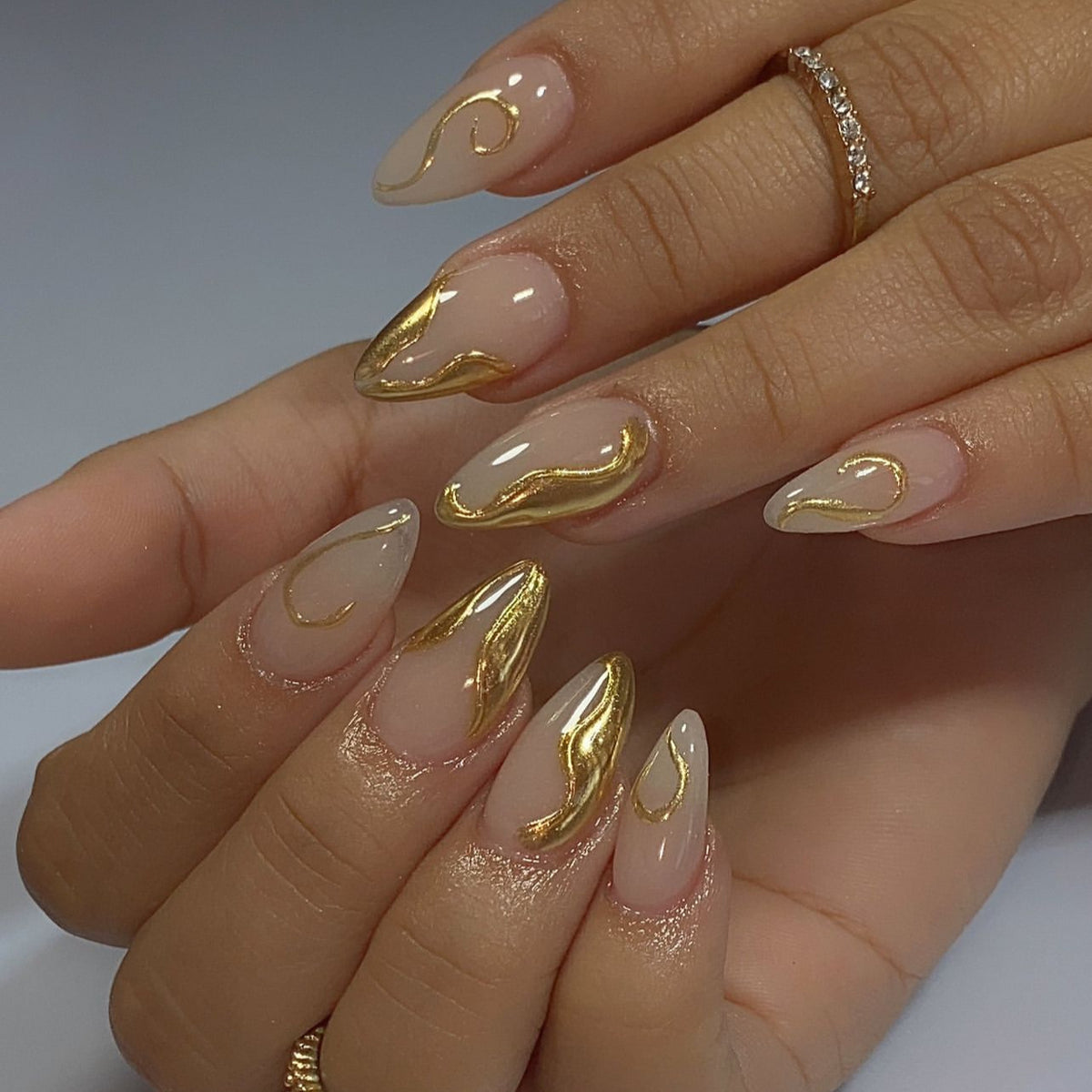 Kunstvolle Stiletto-Nägel mit eleganten Goldakzenten Brehn