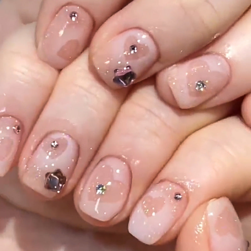 Kunstvolle Nagelkunst mit Glitzer- und Herzmotiven Brehn
