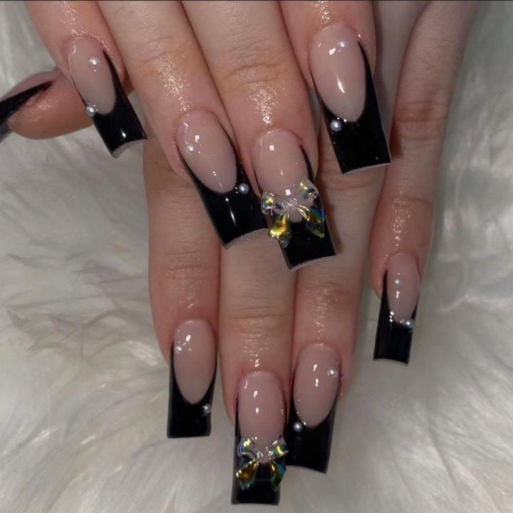Kunstnagelverzierung mit eleganten Schleifen und Strass Brehn