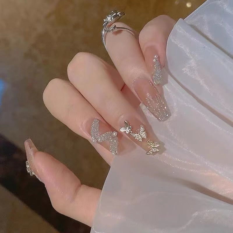 Glamouröse Nagelkunst mit Strass- und Schmetterlingselementen Brehn