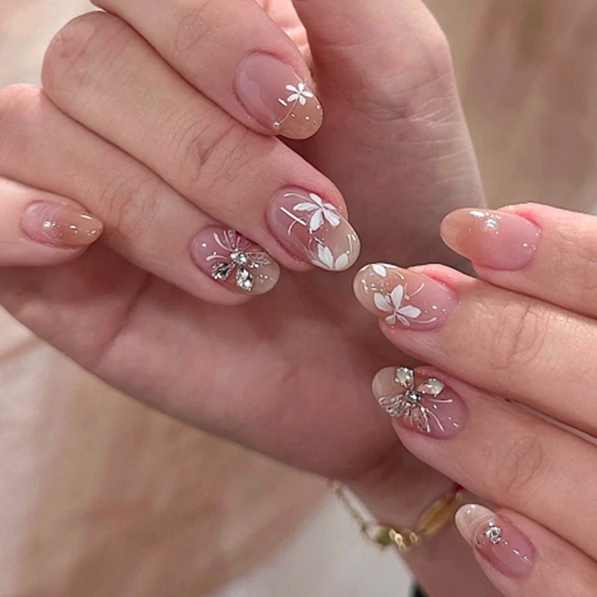 Kunstvolle Nagelgestaltung mit floralem Design und Glitzerakzenten Brehn