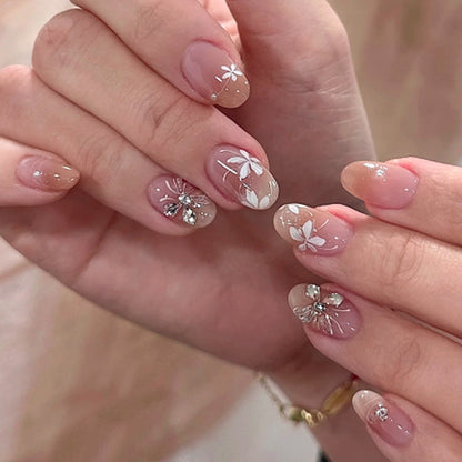 Kunstvolle Nagelgestaltung mit floralem Design und Glitzerakzenten Brehn