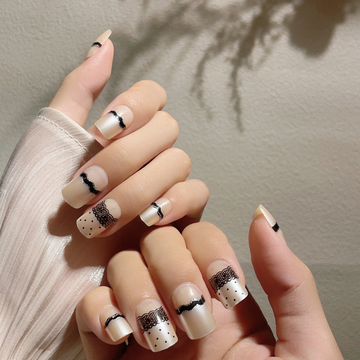 Künstlerisches Press-On-Nageldesign mit Spitze und Punkten