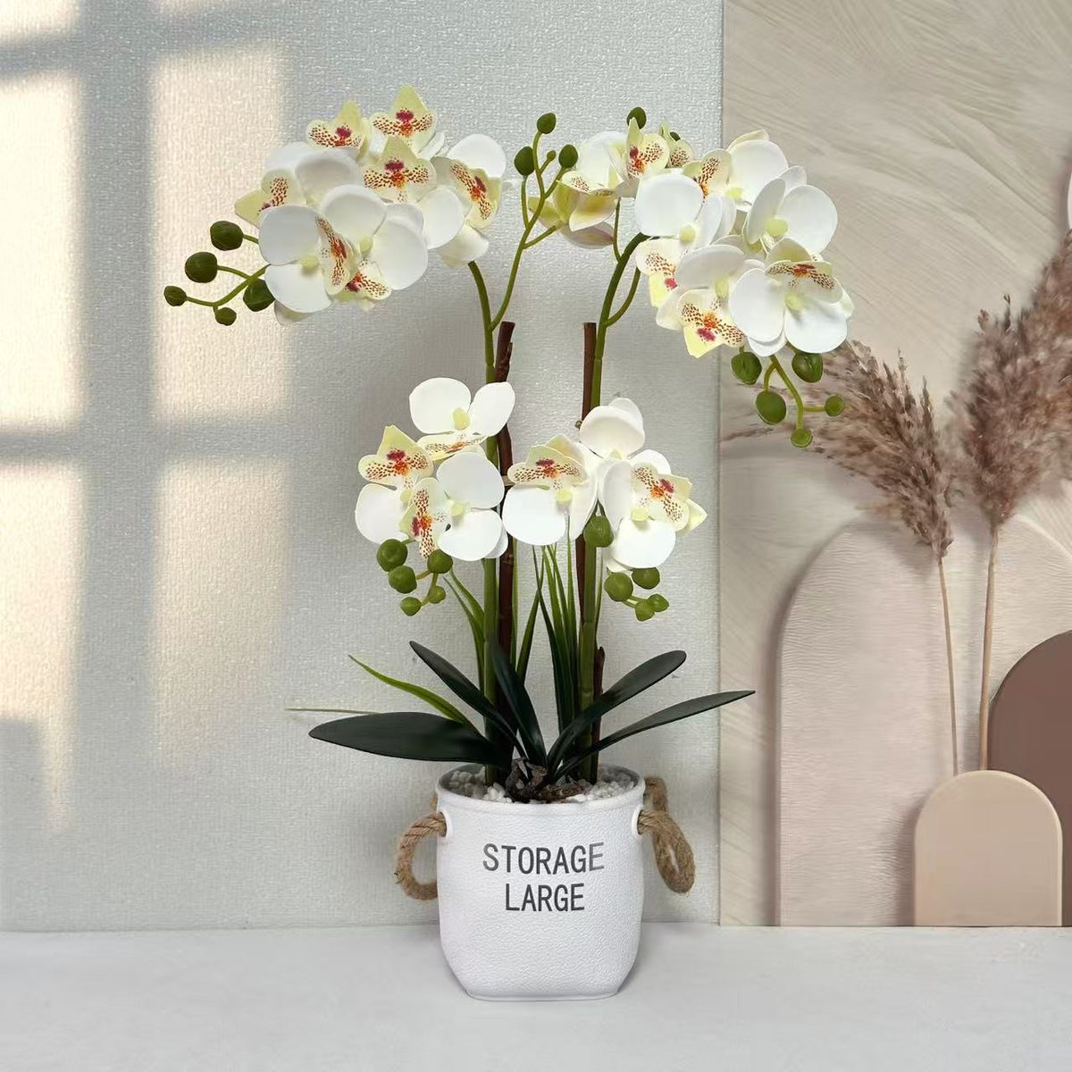 Lebensechte Orchideenpflanze in dekorativem Topf für die Wohnkultur