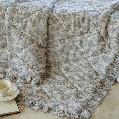 Leicht gesteppte Wohndecke im Vintage‑Blumenprint mit Rüschenrand