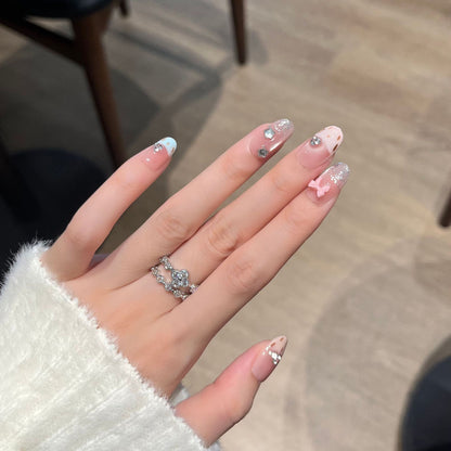 Dekorative Press-On Nagelkunst mit Schleifen- und Edelsteinakzenten Brehn