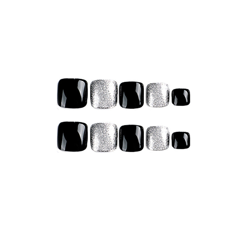 Kunstvolle Fußnagelkunst mit Glitzer- und Schwarzdesign Brehn