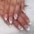 Kunstnagelset mit filigranen Blütenverzierungen und elegantem French Design Brehn