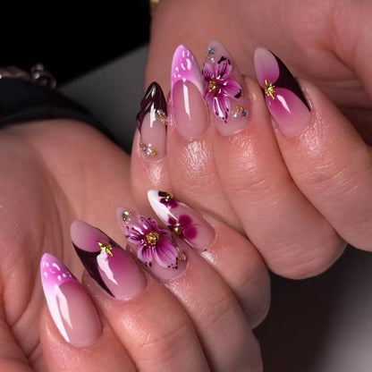 Kunstvolle Stiletto-Nägel mit blühendem Design und Glitzerakzenten Brehn
