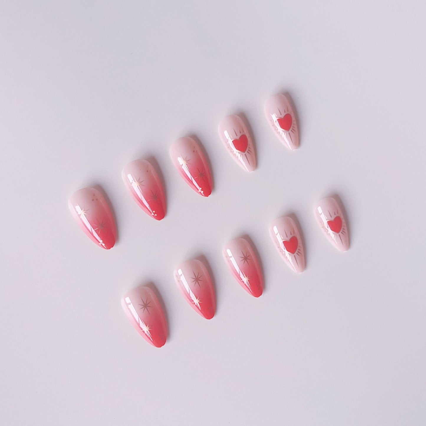 Glamouröse Kunstnagelspitzen mit Herz- und Sternenverzierungen Brehn