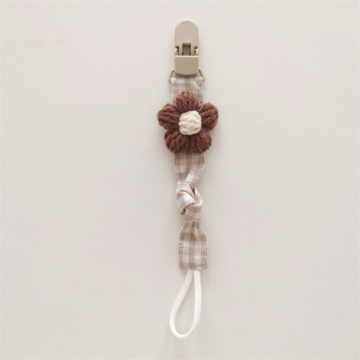 Handgemachter Baumwoll-Schnullerclip mit Gingham-Gurt und gestrickter Blume