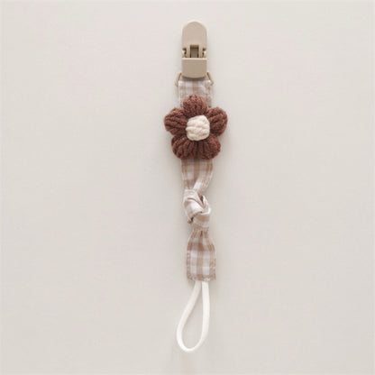Handgemachter Baumwoll-Schnullerclip mit Gingham-Gurt und gestrickter Blume