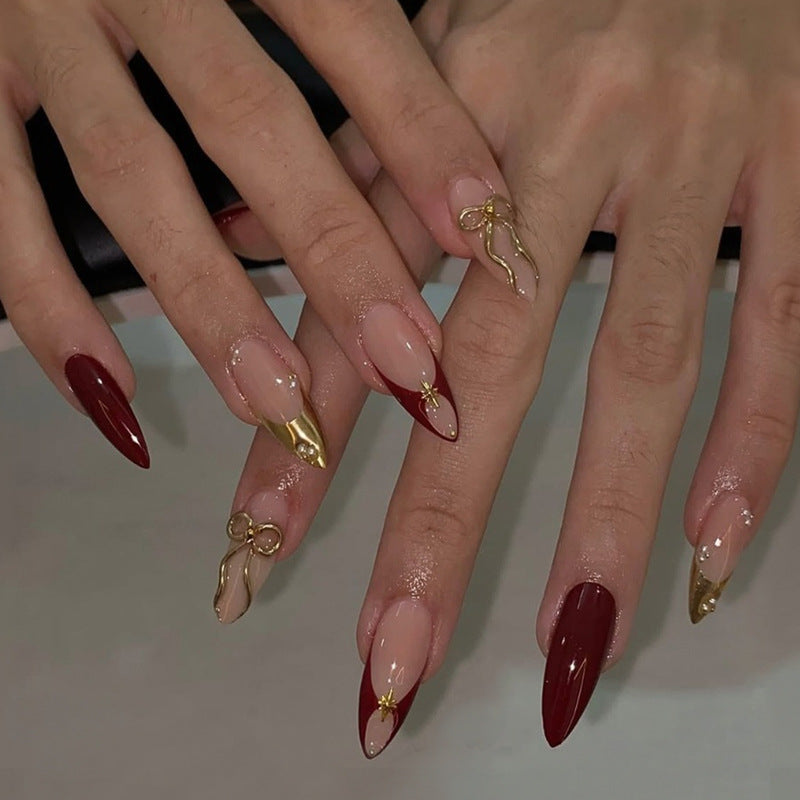 Kunstnagelset mit glamourösen Goldakzenten und eleganten Spitzen Brehn