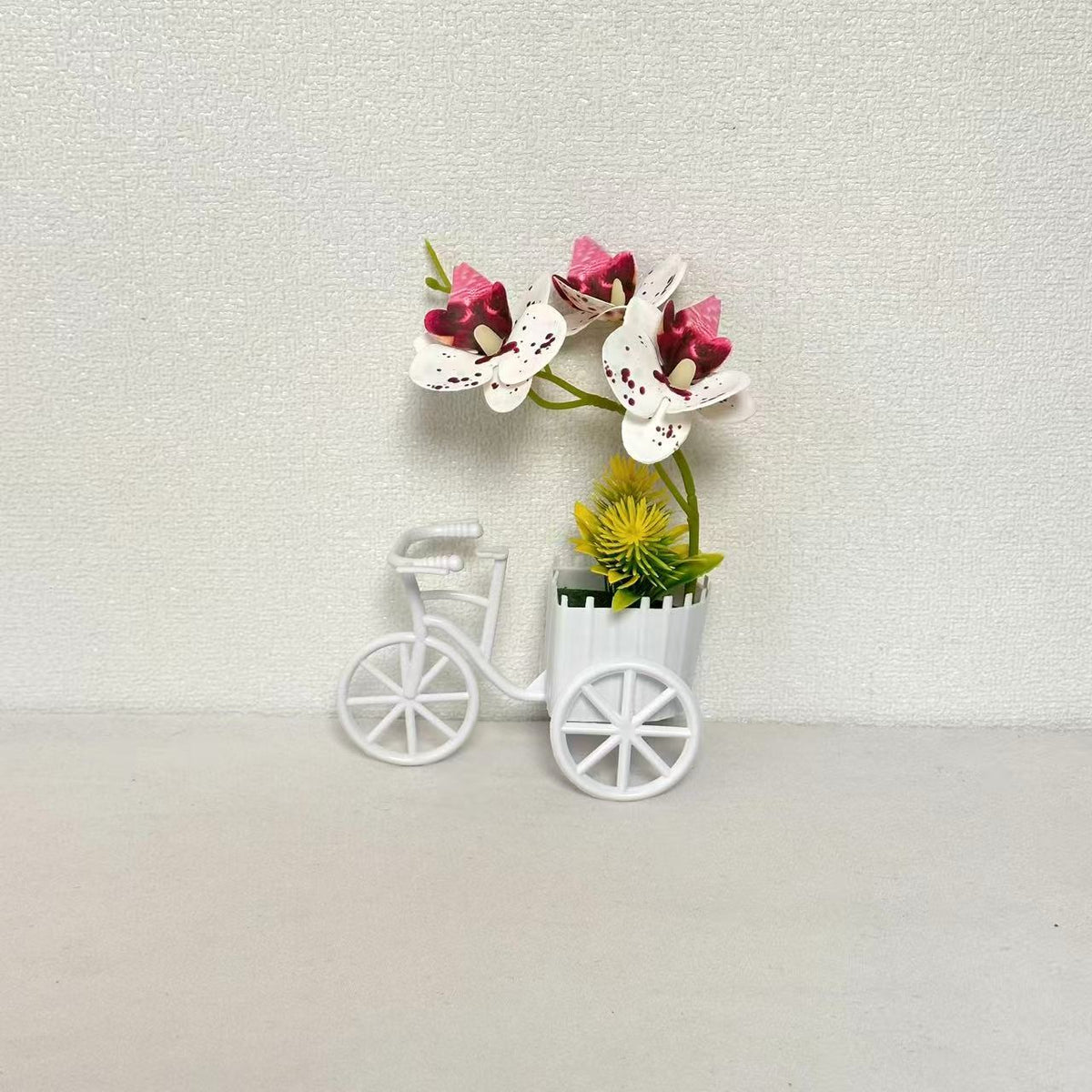 Dekorativer Fahrrad-Blumentopf mit Kunstorchideen-Arrangements für Dekor