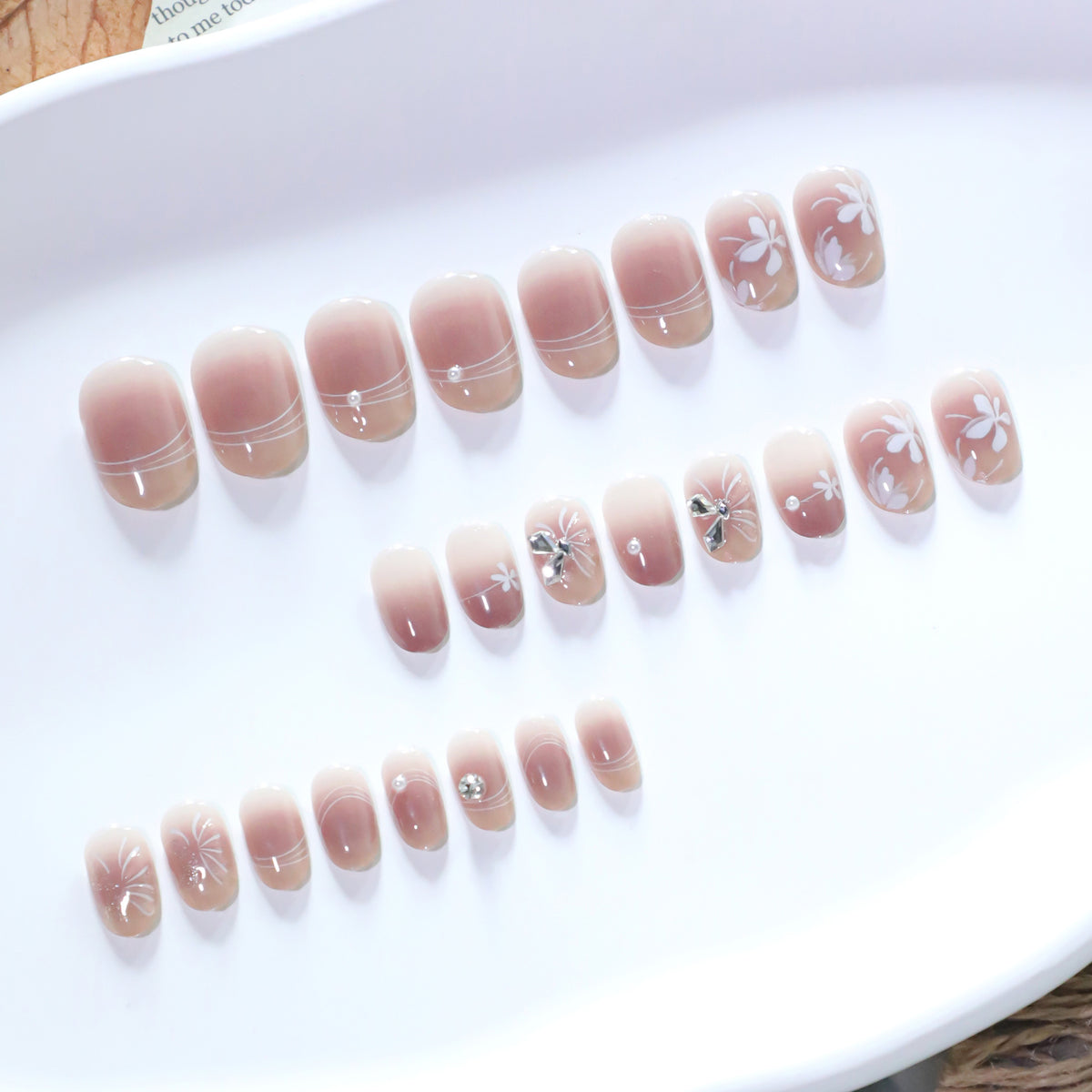 Kunstvolle Nagelgestaltung mit floralem Design und Glitzerakzenten Brehn