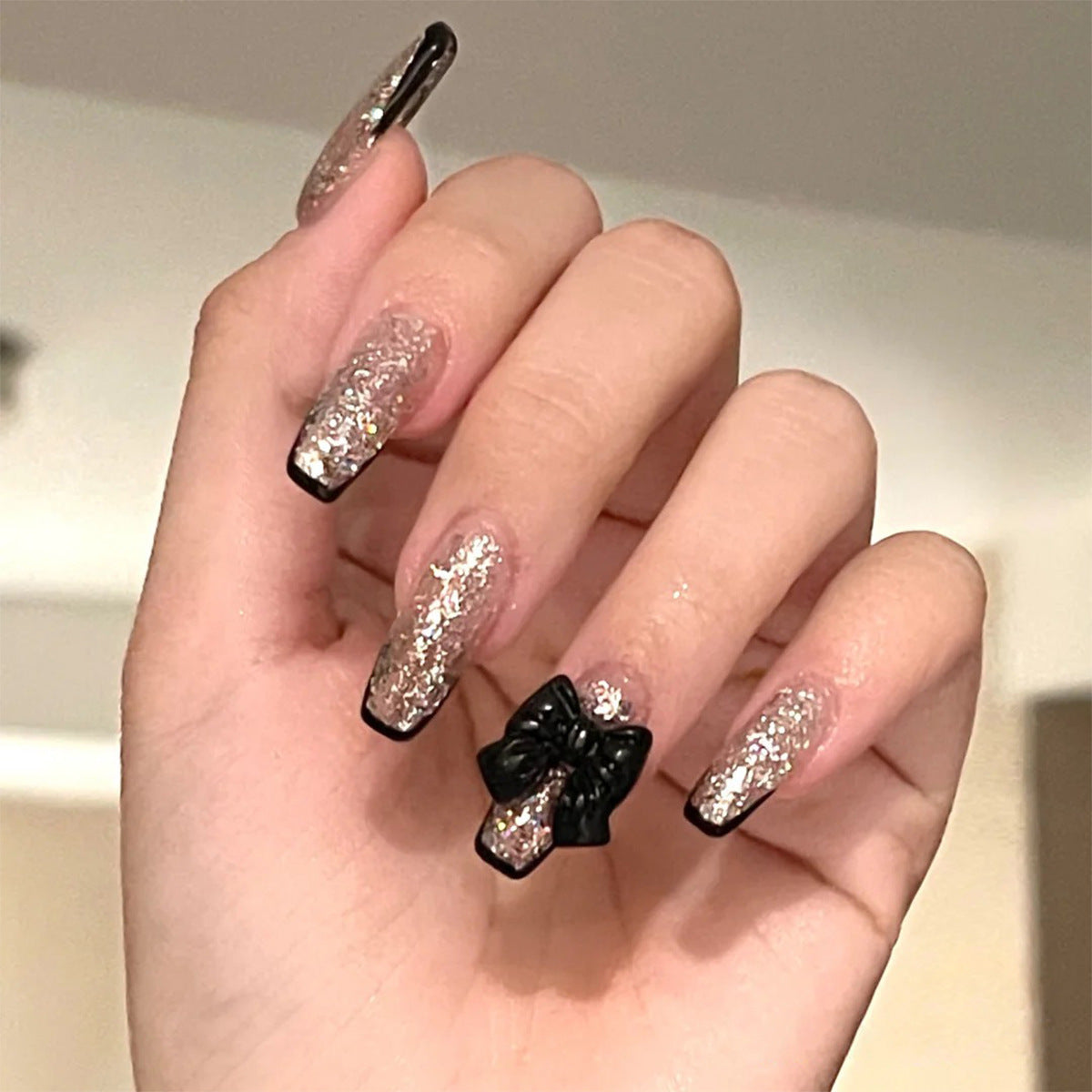 Kunstvolle Nagelverlängerungen mit Glitzer- und Schleifenakzenten Brehn